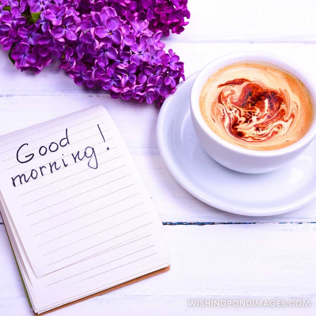 Cappuccino in a white cup and saucer and a paper notepad with the inscription of good morning. Good 